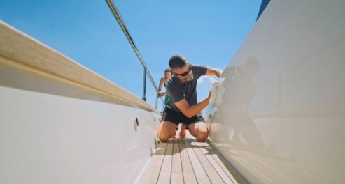 Dos personas limpiando la cubierta de un barco